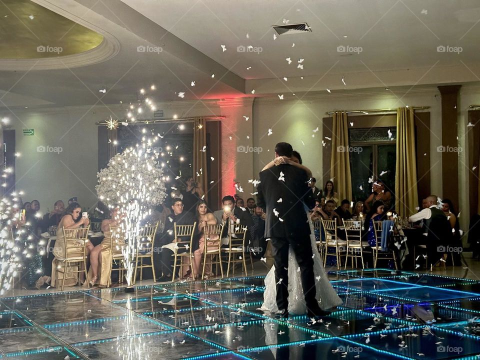 Husband and wife dancing on a luminous platform for the first time on their wedding.