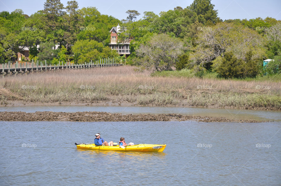 Marsh. Are yellow kayak works its way along Shem Creek and Charleston South Carolina.