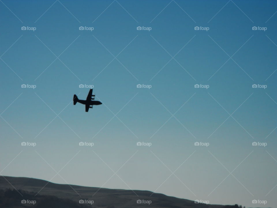 An airplane flying low over the hills in Newtown Powys Wales