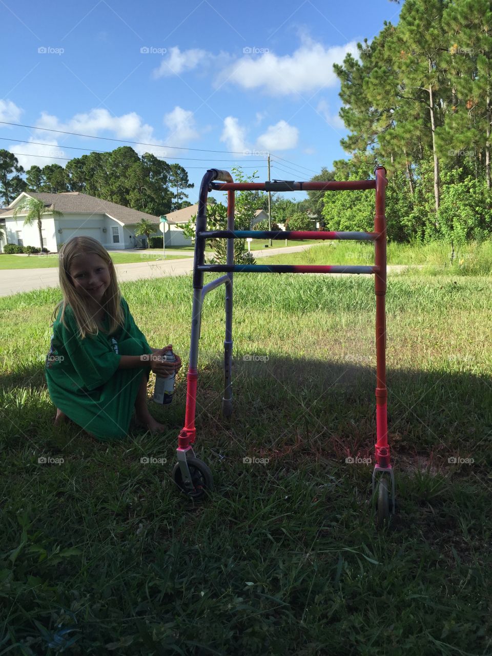 little girl painting her grandmothers walker.