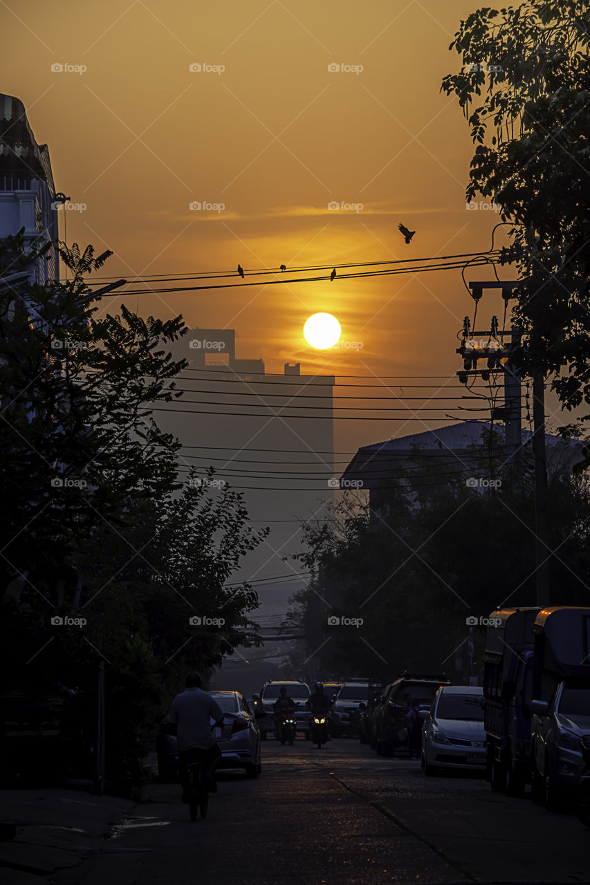 The early morning sunlight shining on buildings and the cars on the road at Bangyai City of Nonthaburi in Thailand.  January 14, 2019