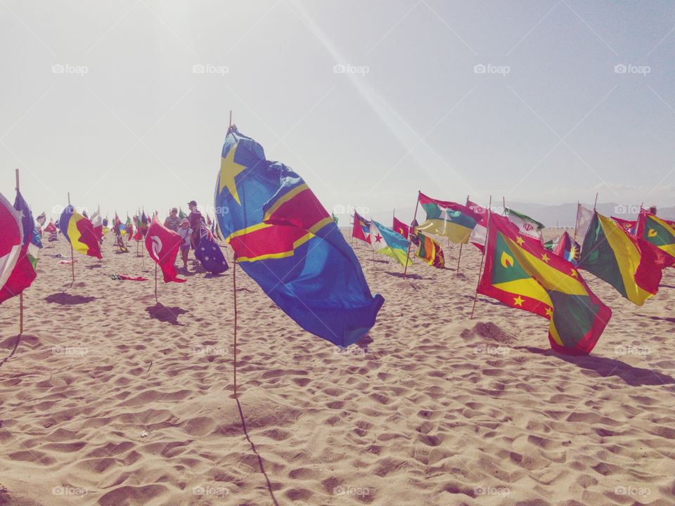 National flags waving in wind on beach. 
