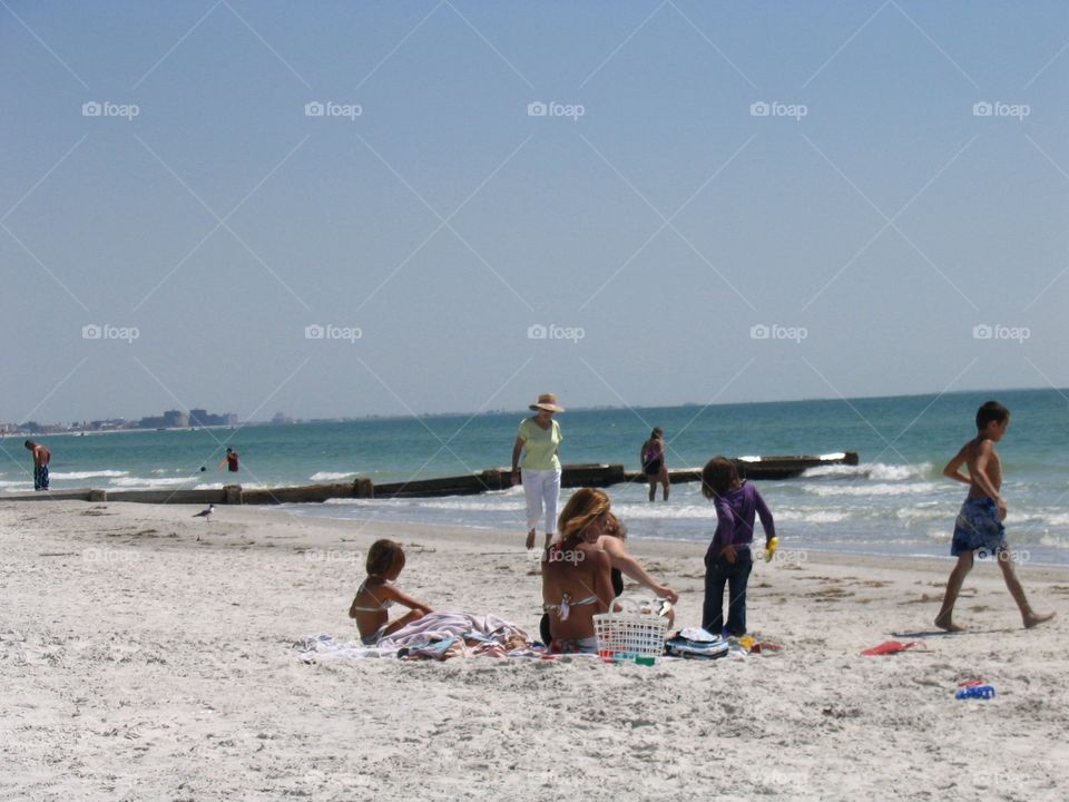 Woman strolling Florida beach, . Woman strolling Florida beach, families on beach