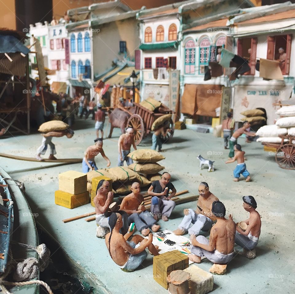 Chinese immigrant figurines in a diorama of 19th century Singapore.