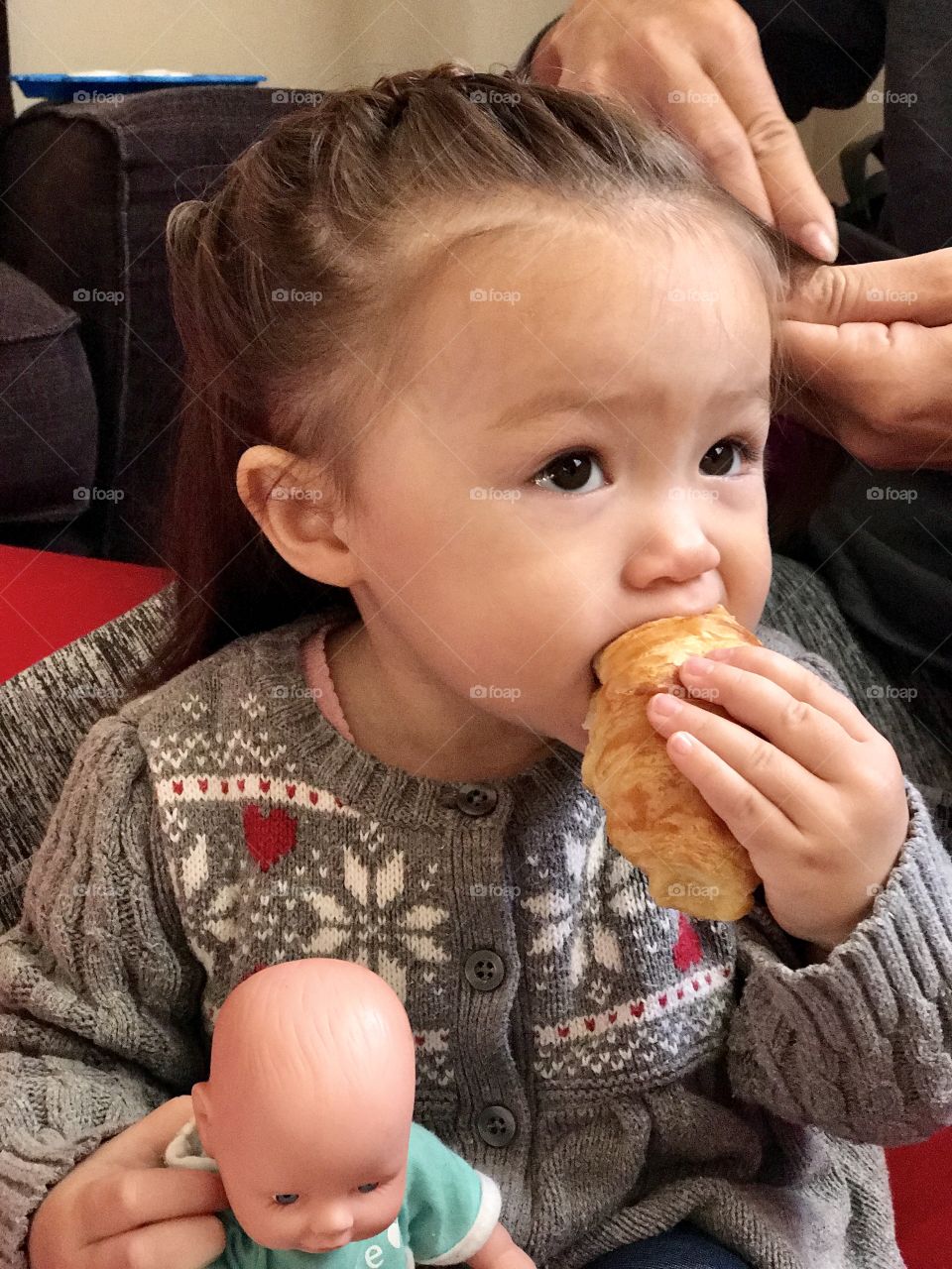 Baby eating croissant and getting hair done