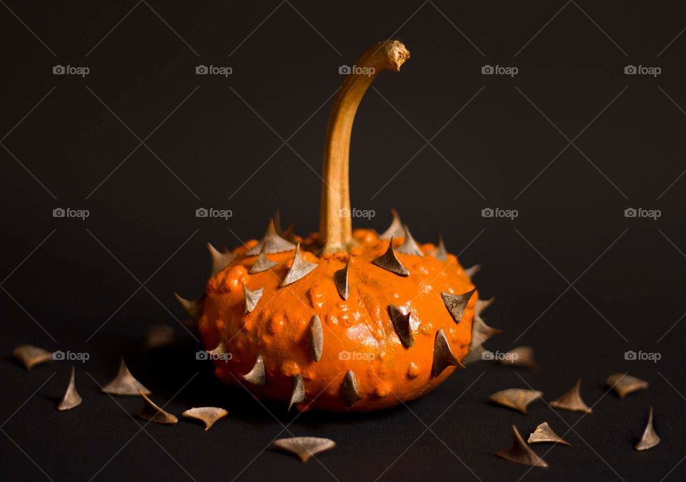 A pumpkin with spikes on black background