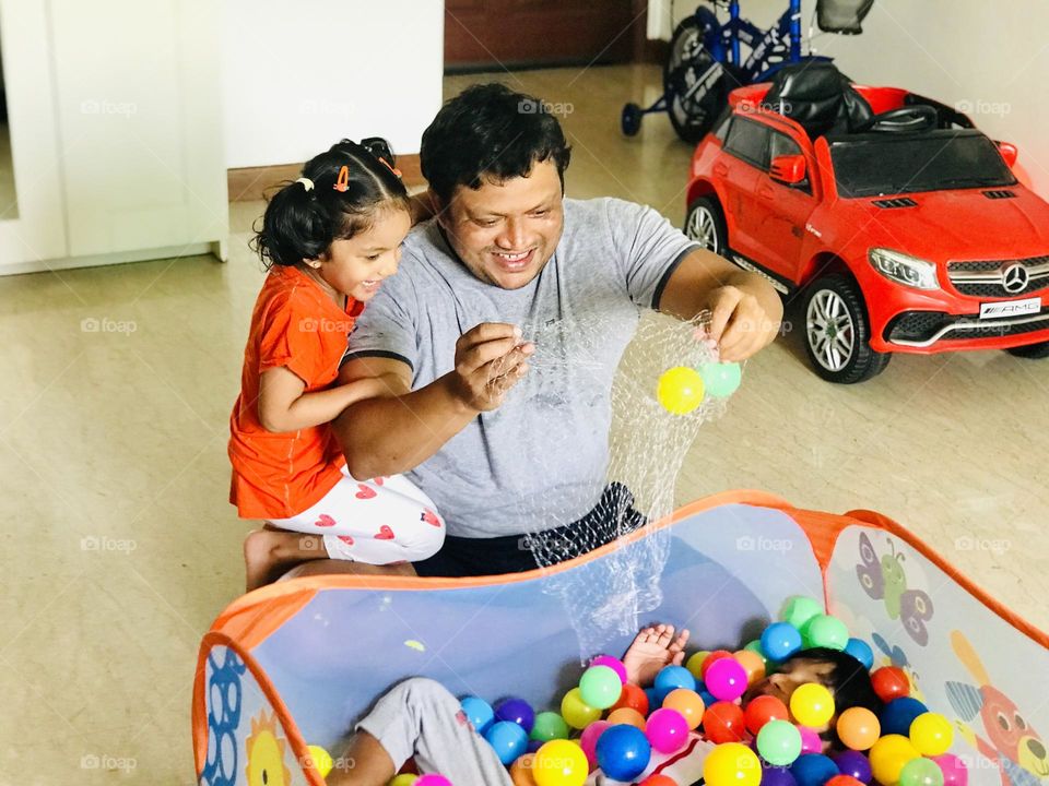 Father pouring balls into ball pit and son in ball pit and they enjoying a lot at home 🏡