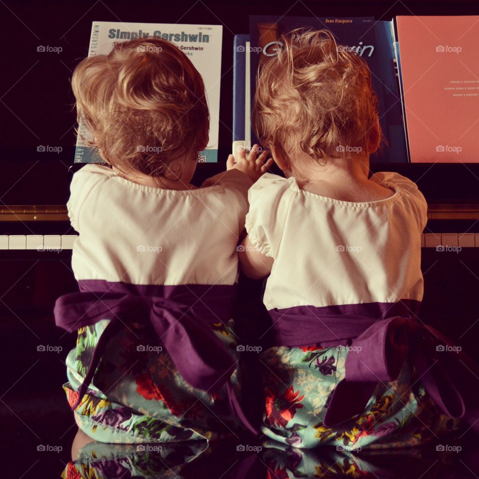 Twin baby girls playing piano duet