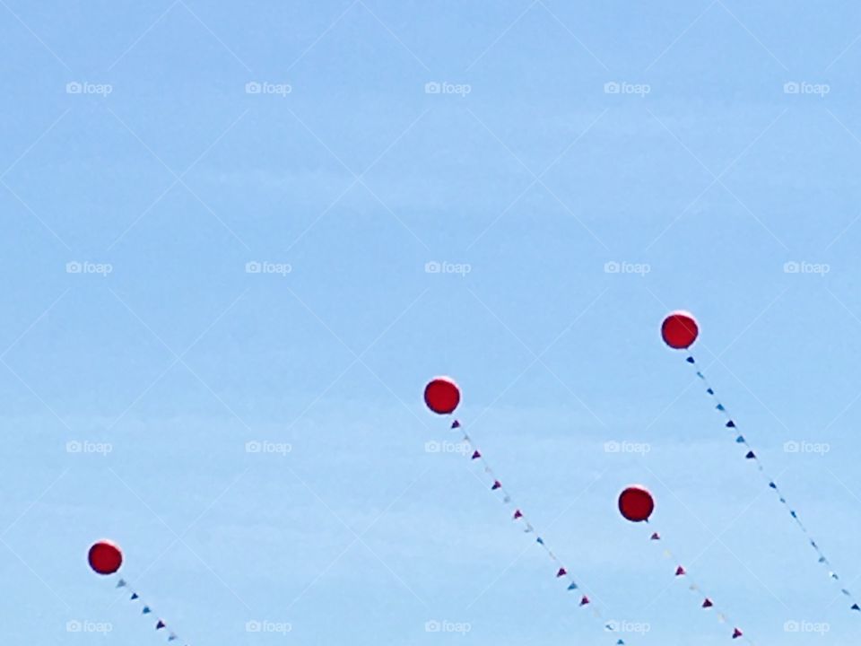 Red balloons floating in the blue sky. 