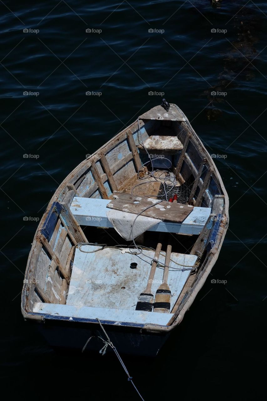 Old rowboat in serious need of fresh paint, revealing what is left of its lovely old blue painted interior.