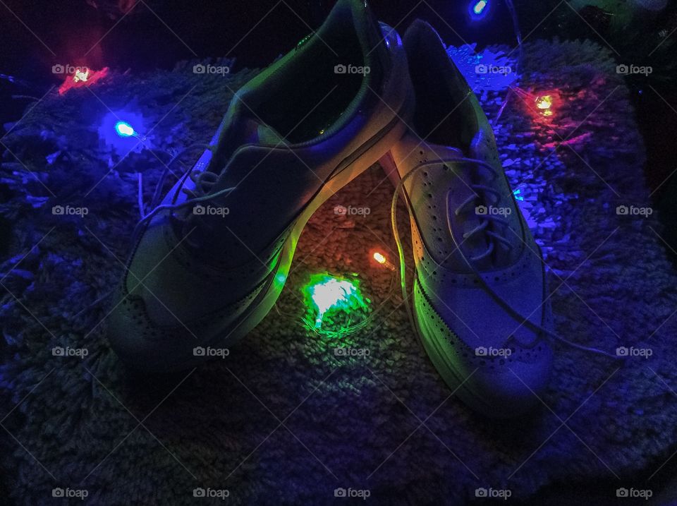 A delicadeza dos sapatos ao se misturar com a intensidade das luzes compõe uma foto perfeitamente leve, natalina