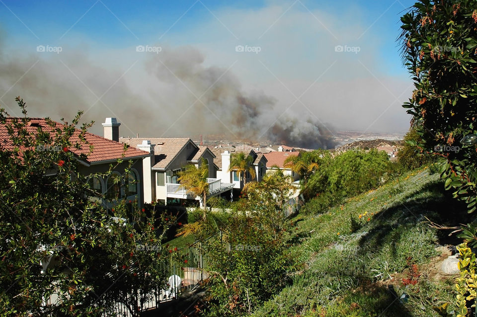 Smoke from a wildfire rises threatening a house development in Southern California.
