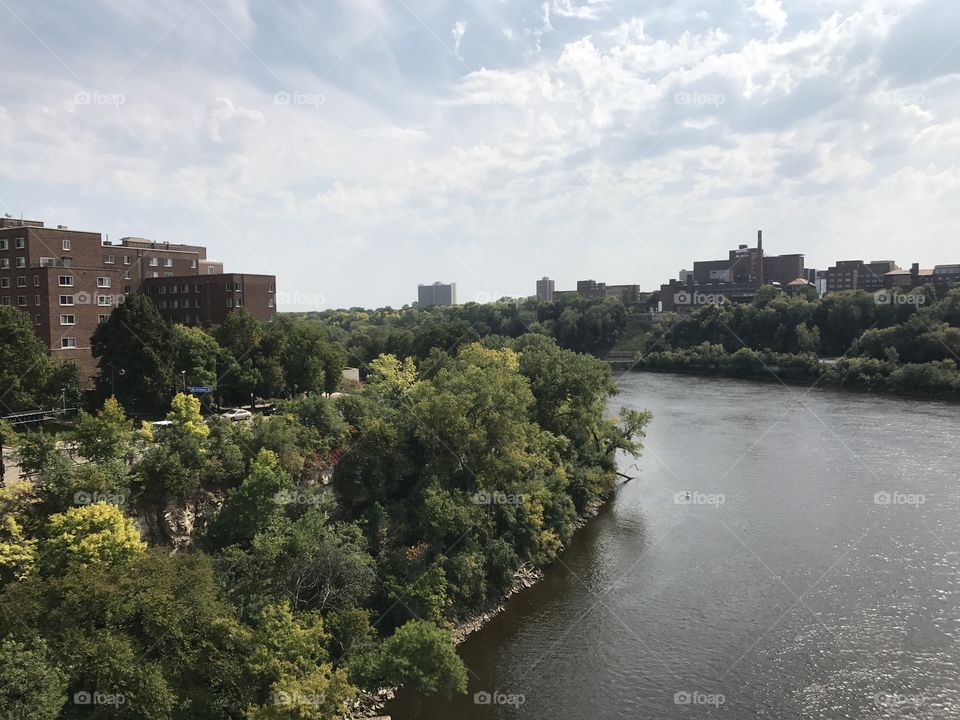 Sunny, cloud-filled overlook of the Mississippi River from Washington Ave. bridge in Minneapolis