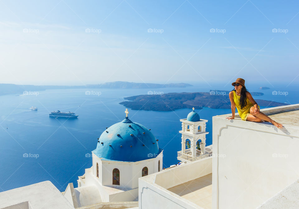 Female tourist enjoying peacefully with the view of Santorini famous landmarks, Mediterranean sea, Greece 