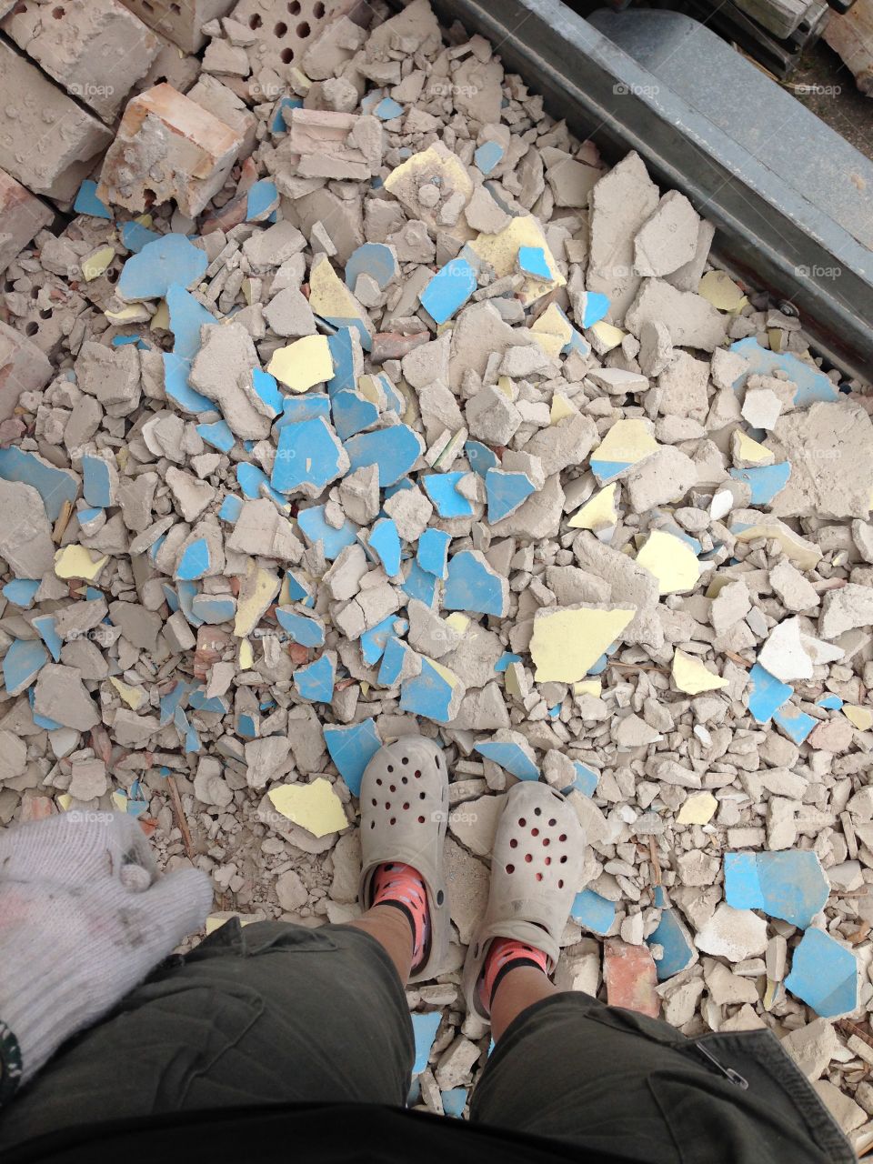 Standing in a pile of junk which used to be a wall.