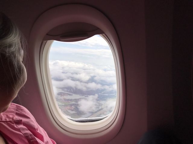 Lovely lady enjoying an areal view through a jetliner’s window.
