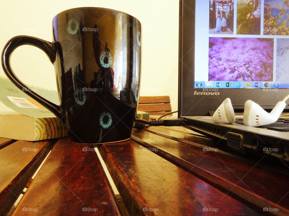laptop, earphones and mug of coffee on my desk
