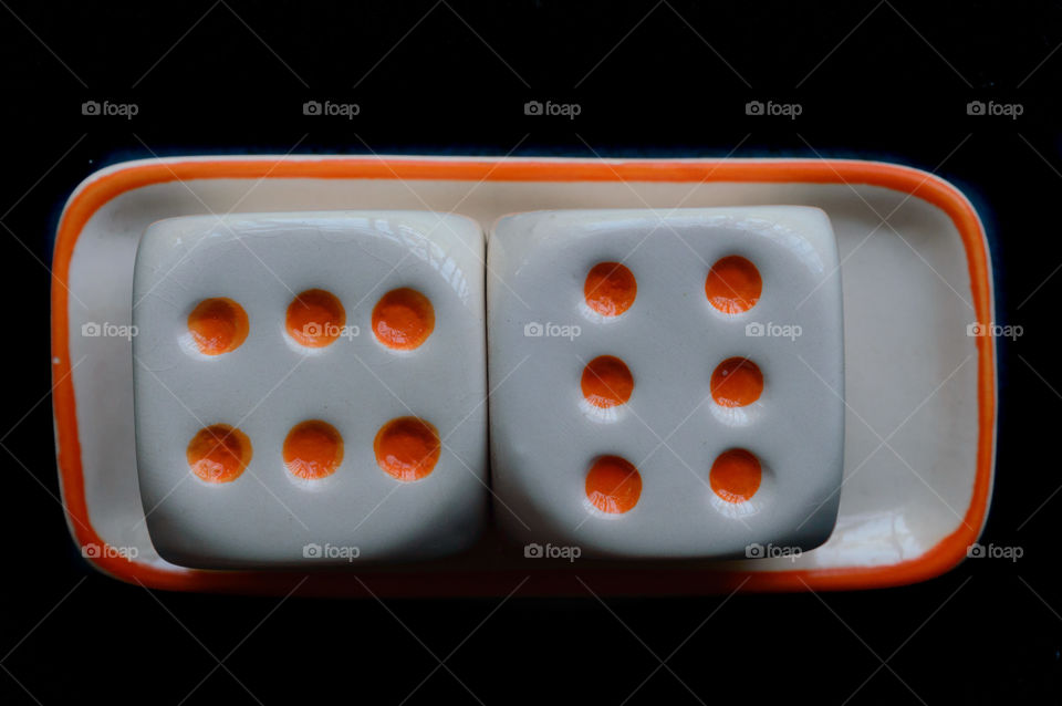 Selective focus on dices: Casino cube dice set. Number 6 gambling dices or red gaming dices on black background. Room for text. Game object or parlor gaming concept.