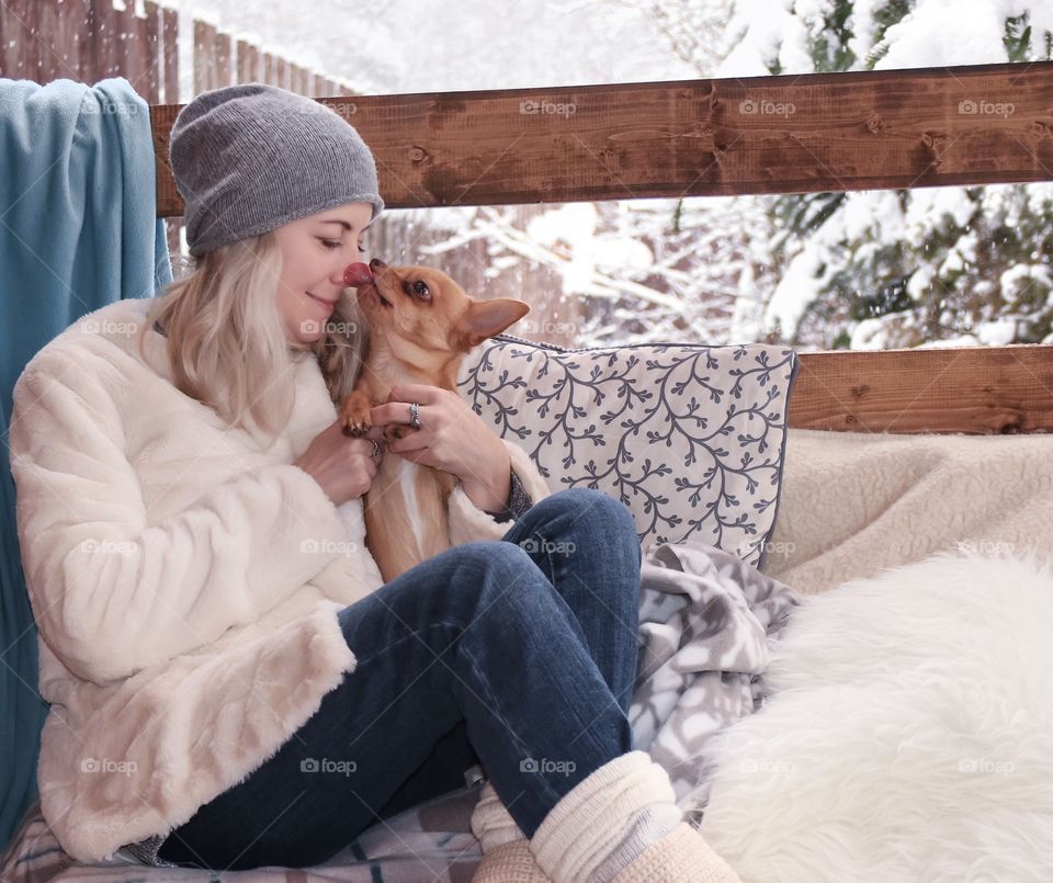 Small dog licking a woman's face