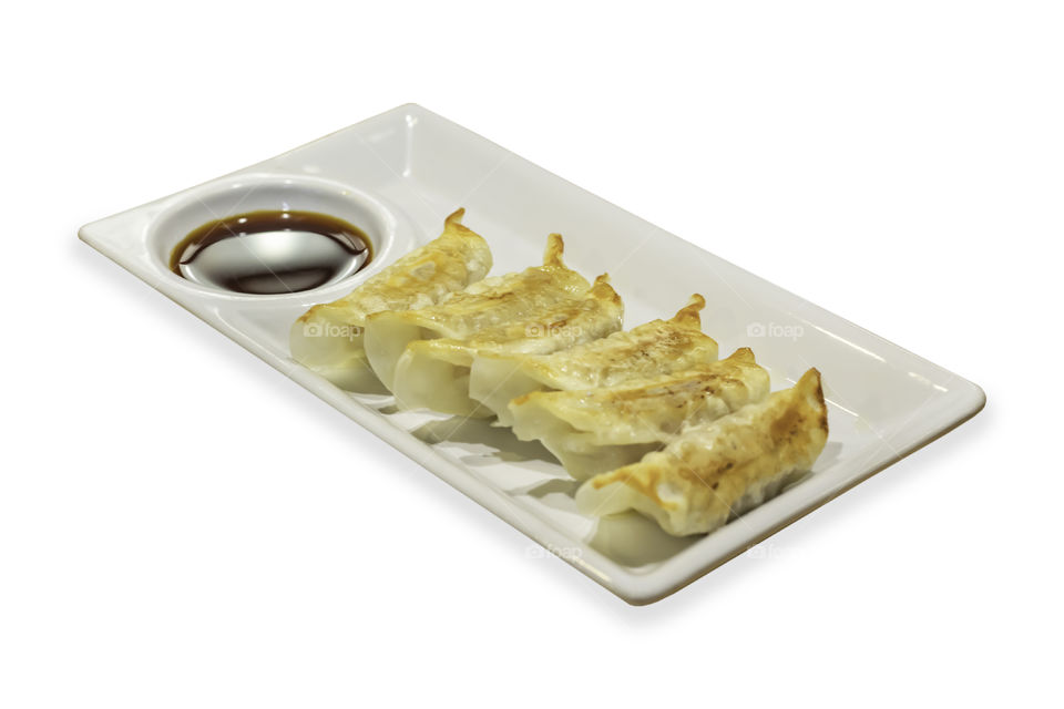 Gyoza and sauce in plate on a white background with clipping path.