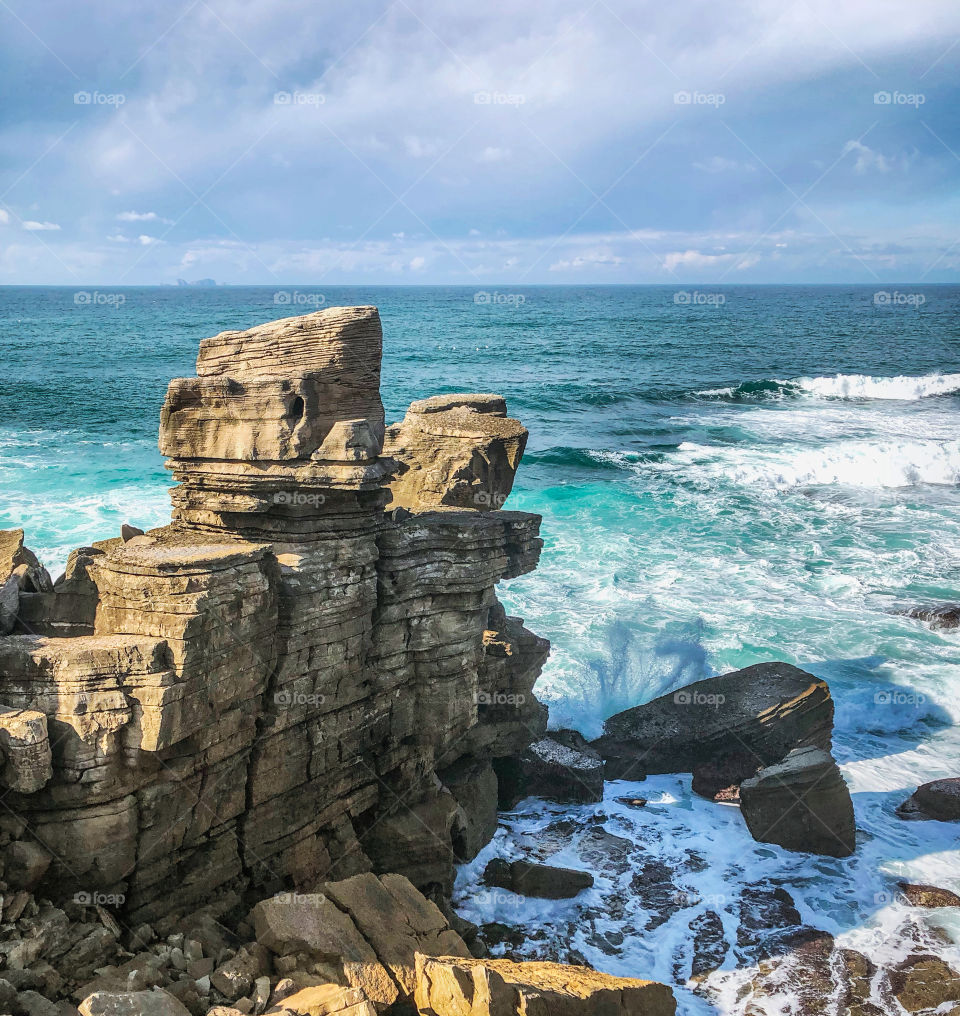 Waves crash against the eroded cliffs at the Peniche Peninsula, Portugal