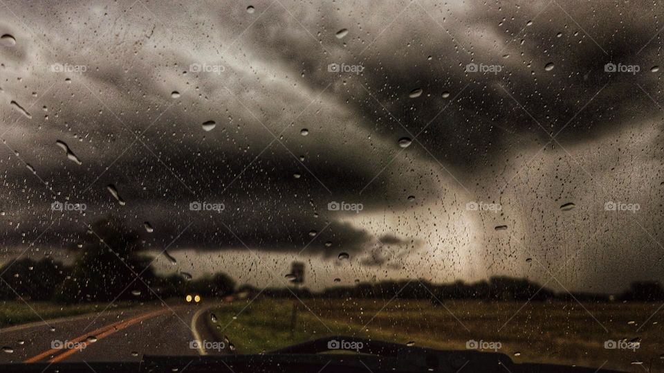 Spring Storm Clouds and Rain While Driving Down the Road woth Headlights Approaching