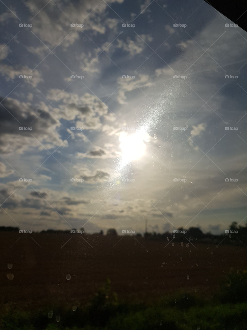 sky with clouds and sun seen from the bus