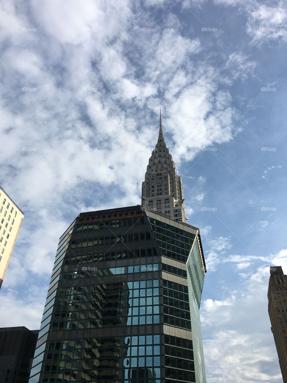 Gorgeous view of the skyline from street level. Looking up to the blue sky with soft clouds forming just behind the building