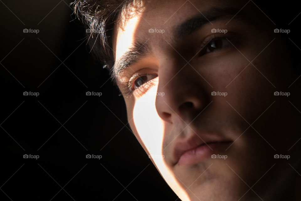 Young man's face cast in a strong shadow