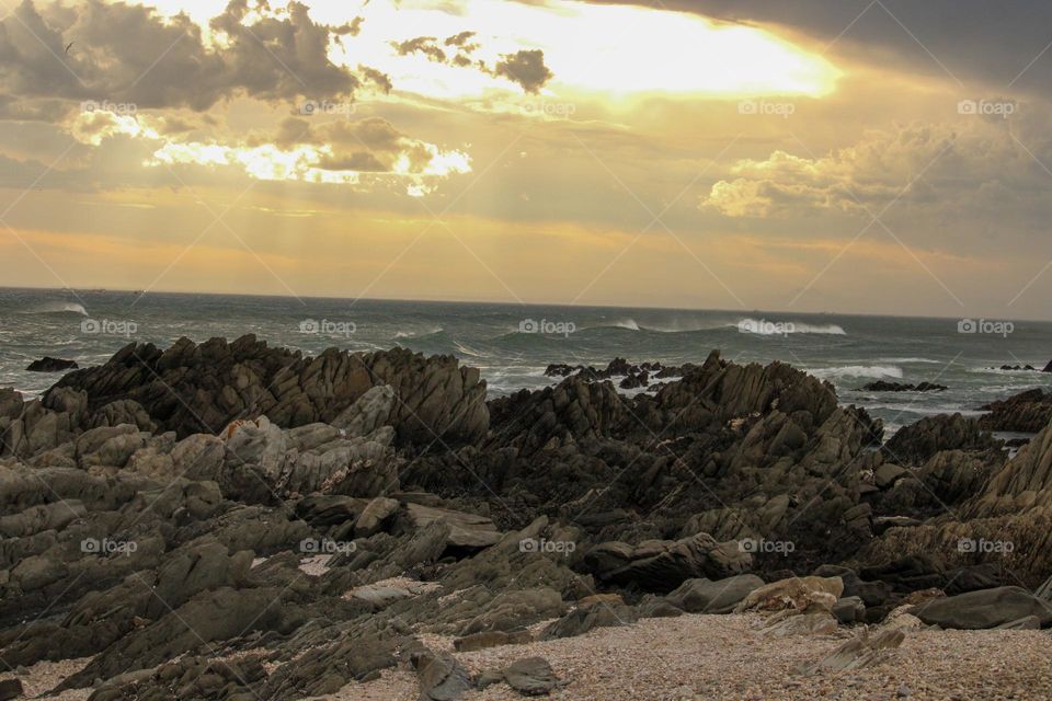 A sunset at the sea on a overcast day