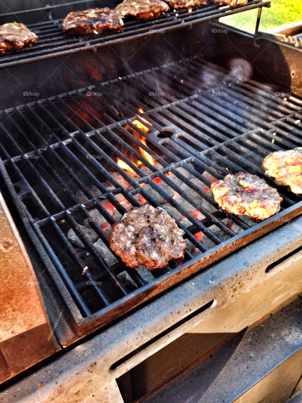 Flame broiled. Burgers cooking on a grill