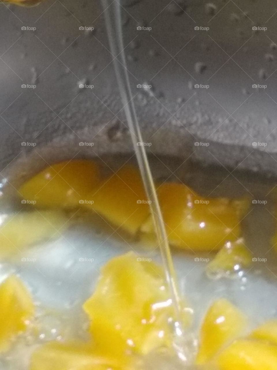 The water from the peaches pouring slowly in small funnel-like🌪️ shape.