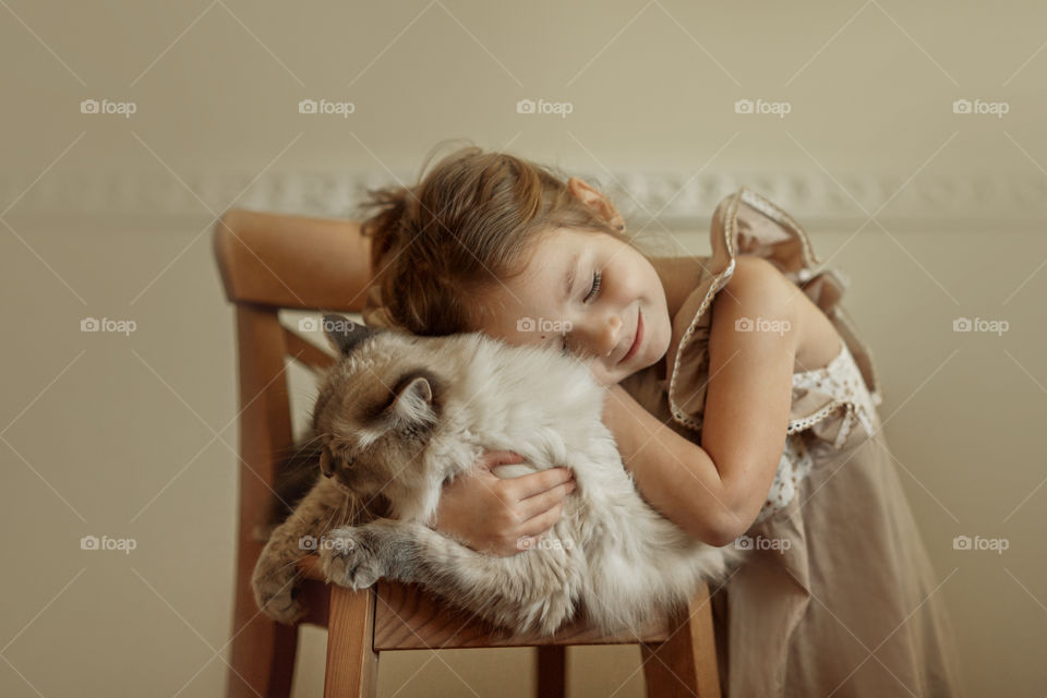 Vintage portrait of a beautiful little girl with rag-doll cat