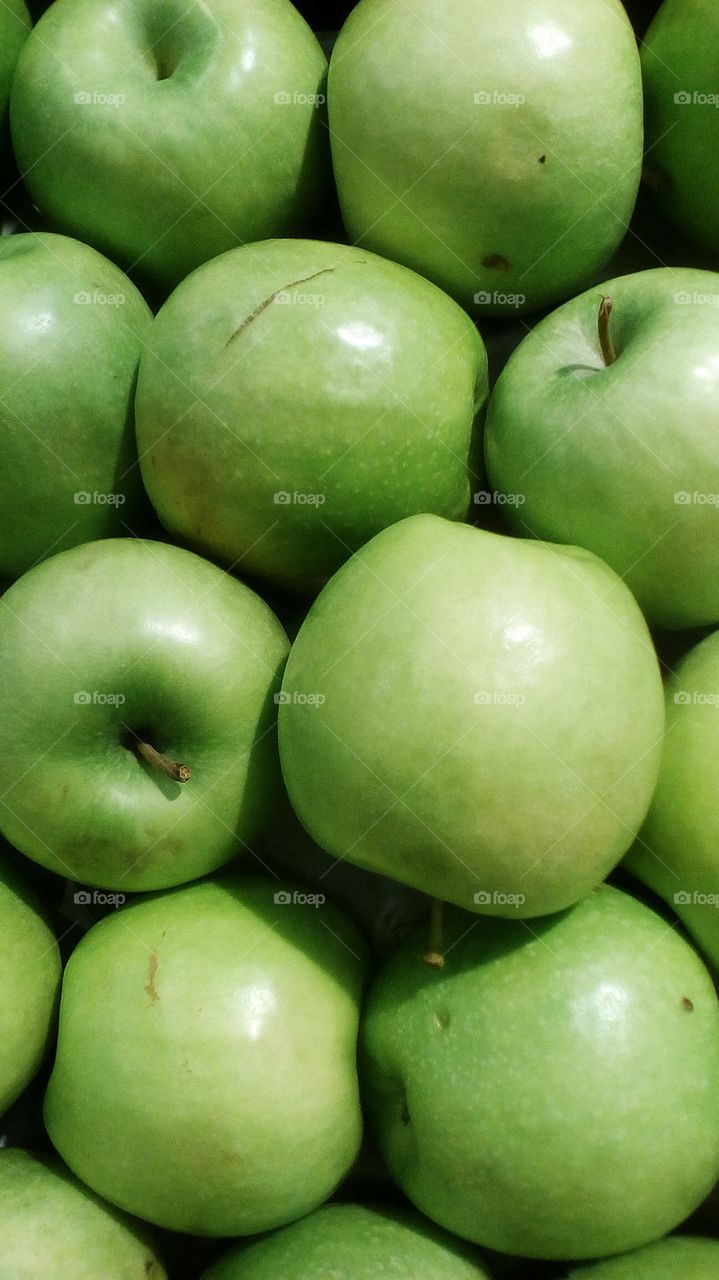 Many round green bright beautiful
apples in market