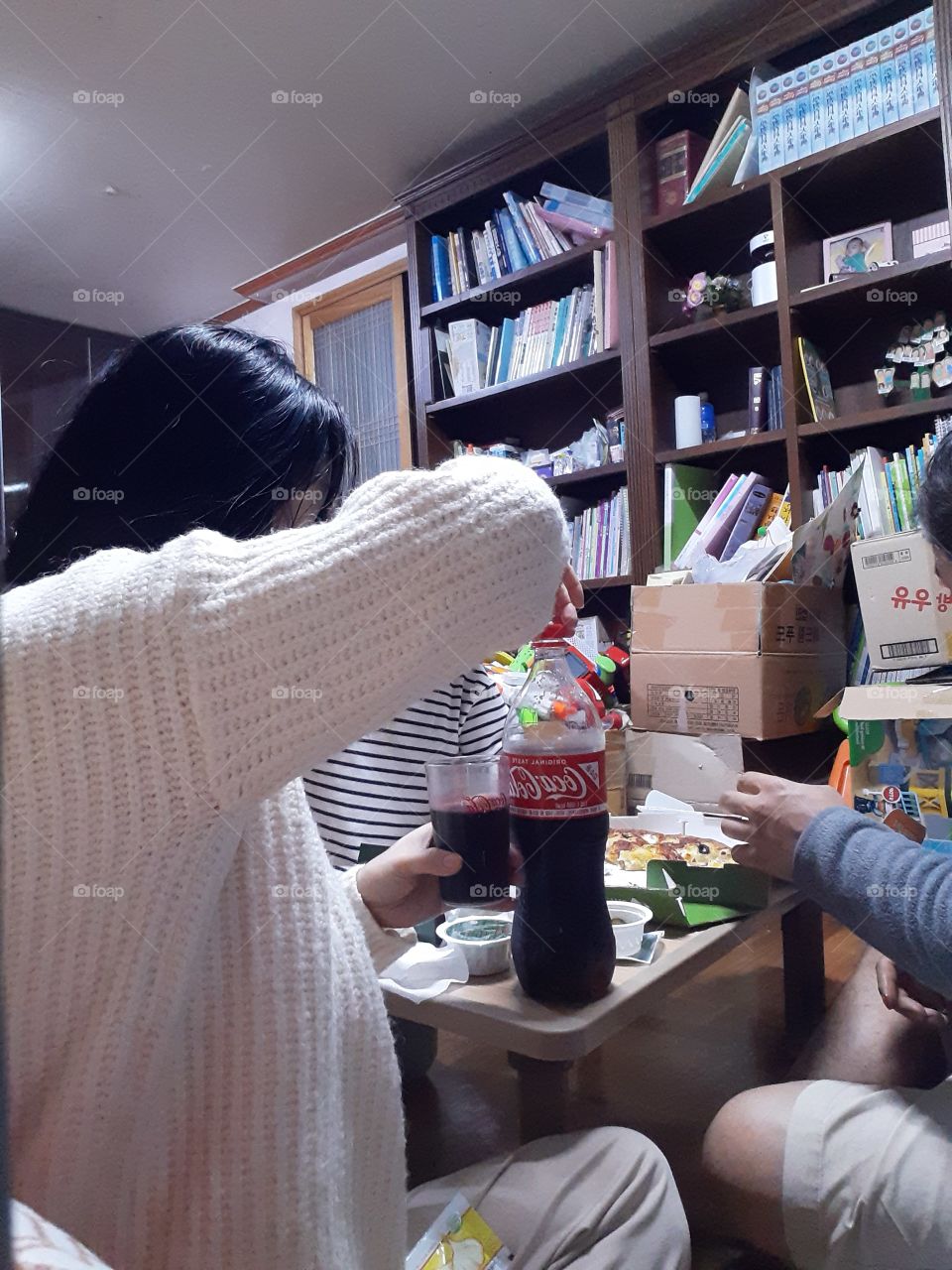 pouring some coca cola in the glass to share with family