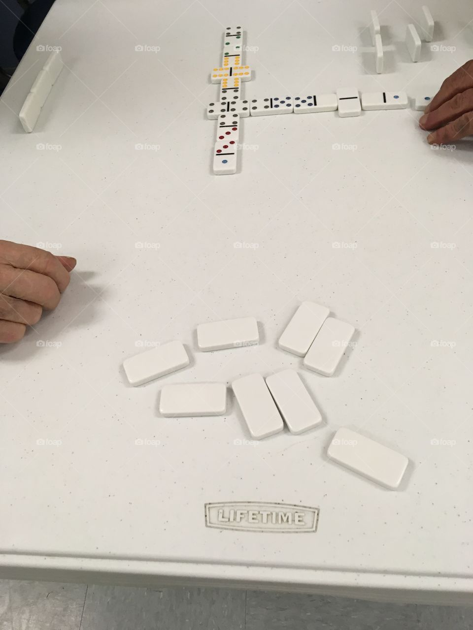 Two men playing a simple game of dominoes at the senior center today. One of the many games.