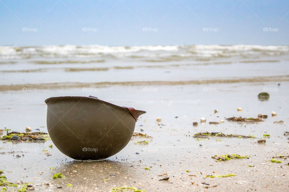 Landing beaches of June 6, 1944 in Normandy. Utah beach. Helmet of a parachutist on the sand. The longest day.