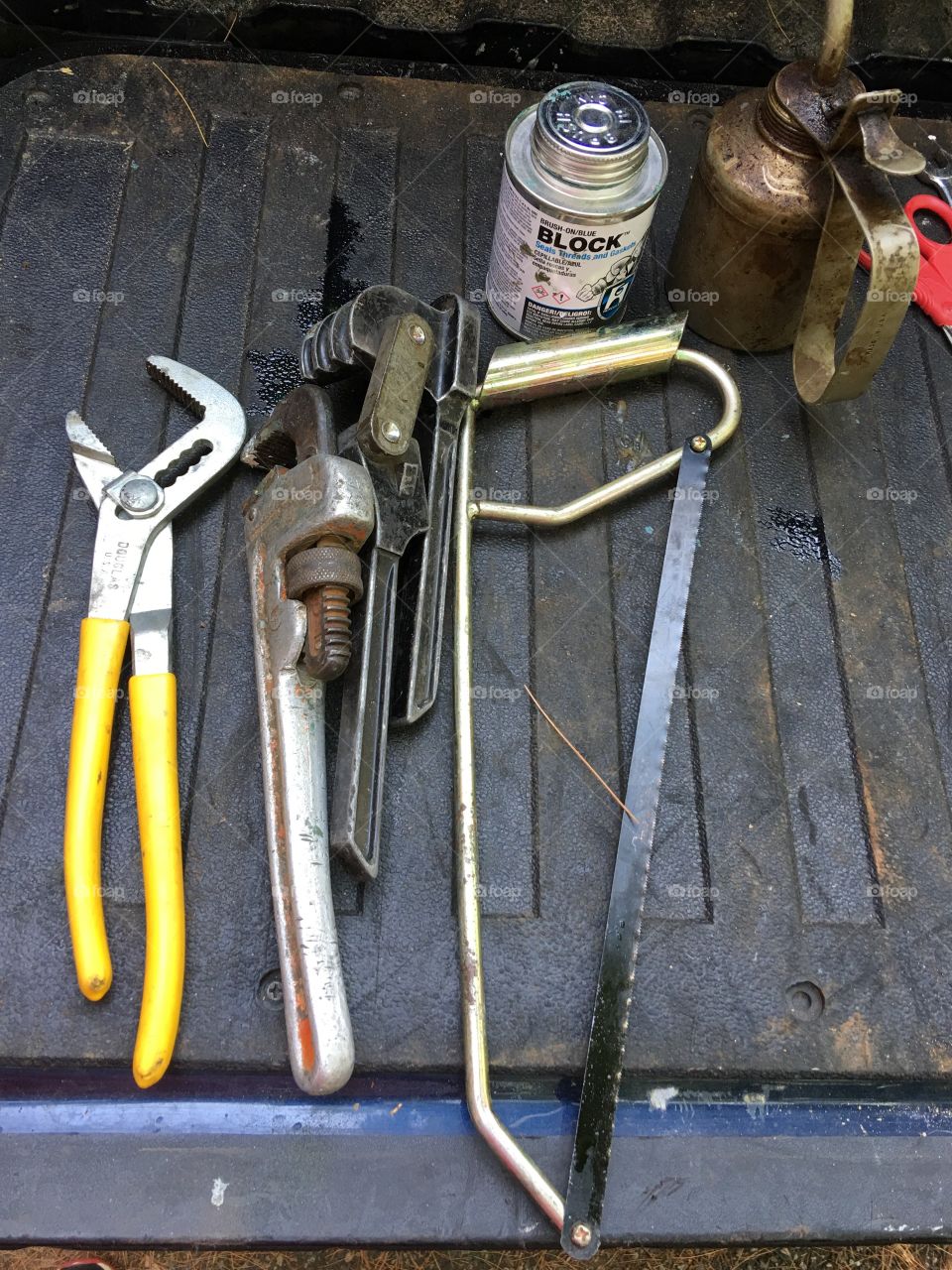 Layout of plumbers tools. Wrenches, solder, hand saw, glue pvc pipes, etc.