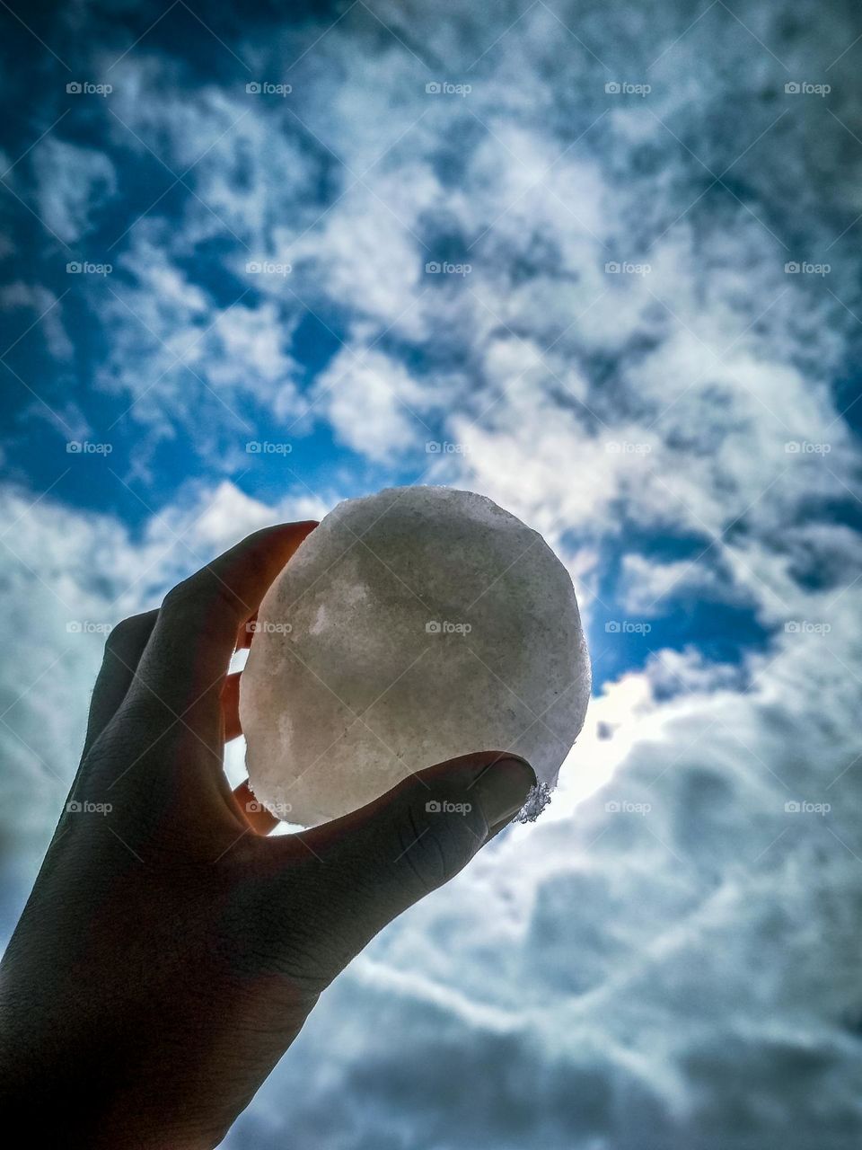 a snow ball in hand and the background view.