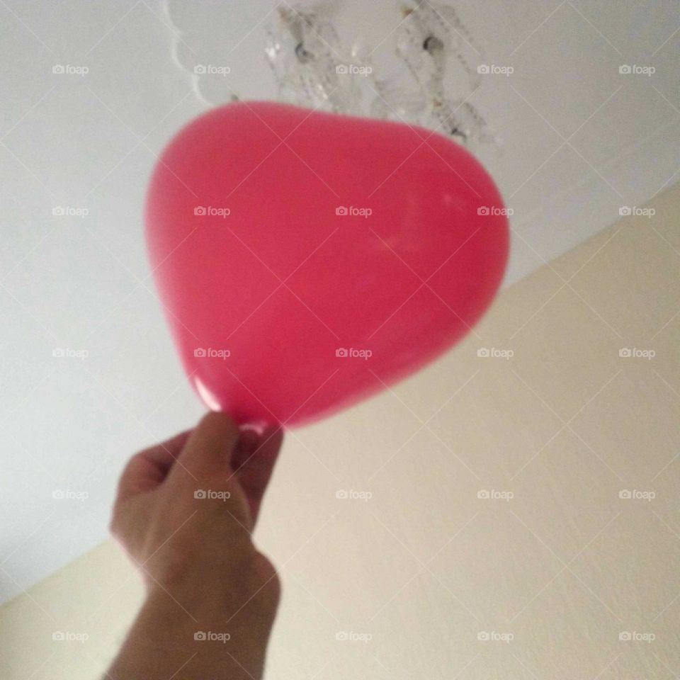 A hand holding red ballon