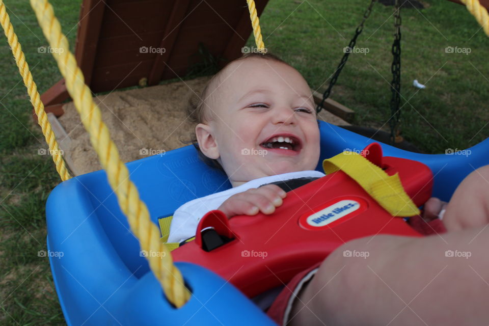 Baby in complete happiness. This is a photograph of a baby in a swing in complete happiness.
