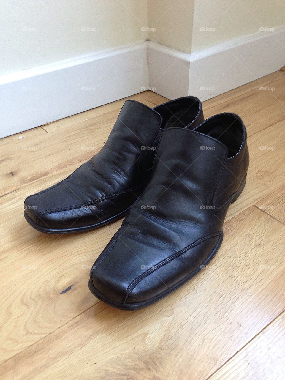 Mens black shoes on a wooden floor