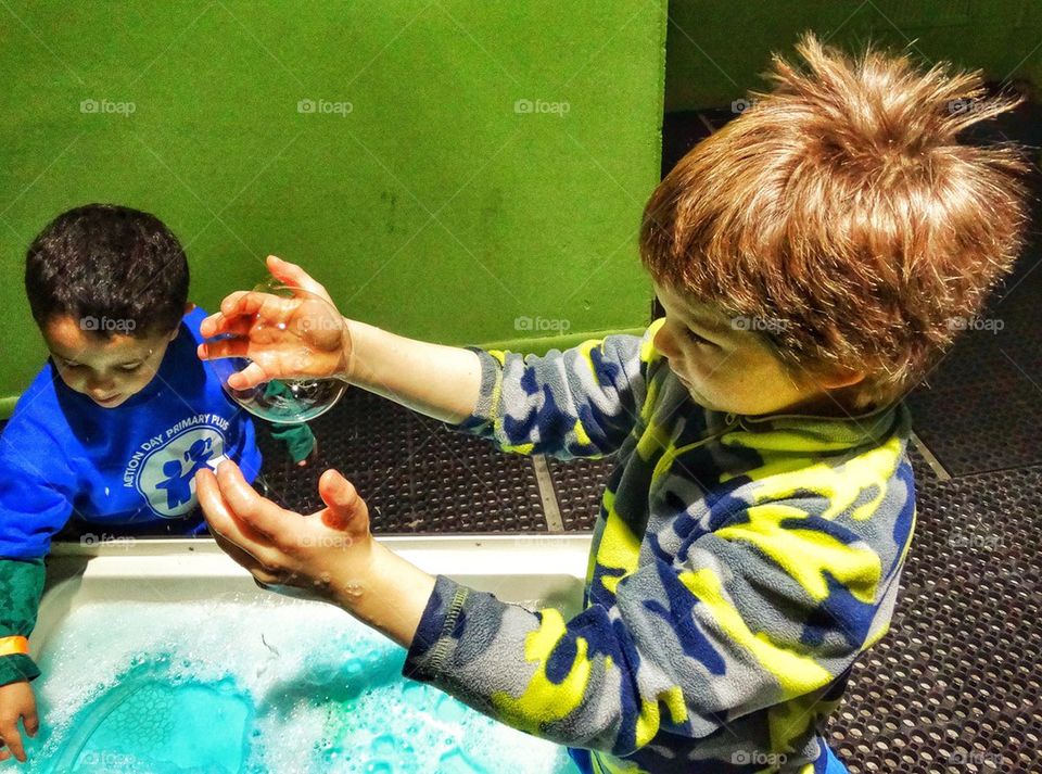 Playing With Giant Soap Bubbles. Children Experimenting With Soap Bubbles On A School Field Trip
