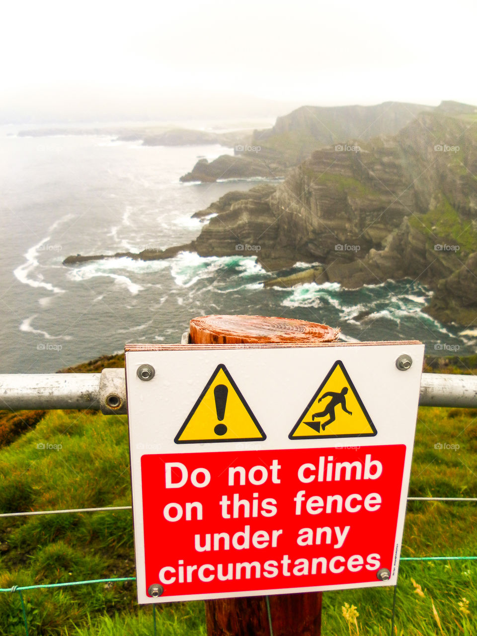 Sign board giving perspective on height of the amazing Kerry Cliffs, County Kerry, Ireland. These spectacular cliffs are a local tourist attraction in Ireland.