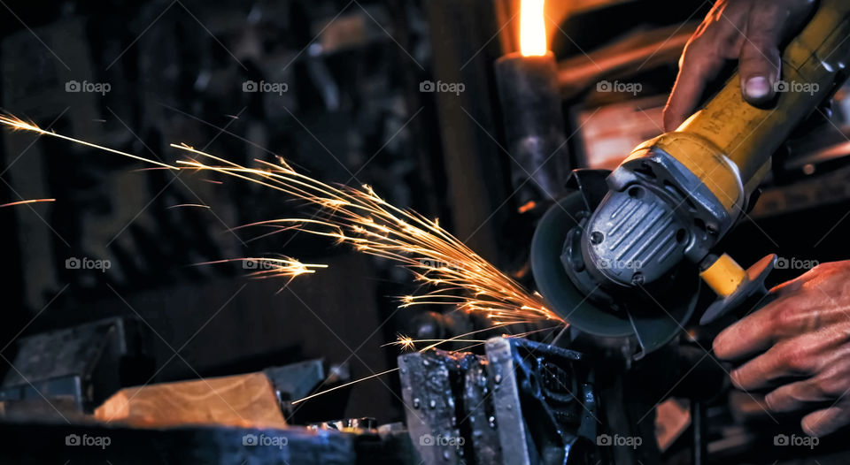 sparks made by using electric disc grinder polishing the surface metal