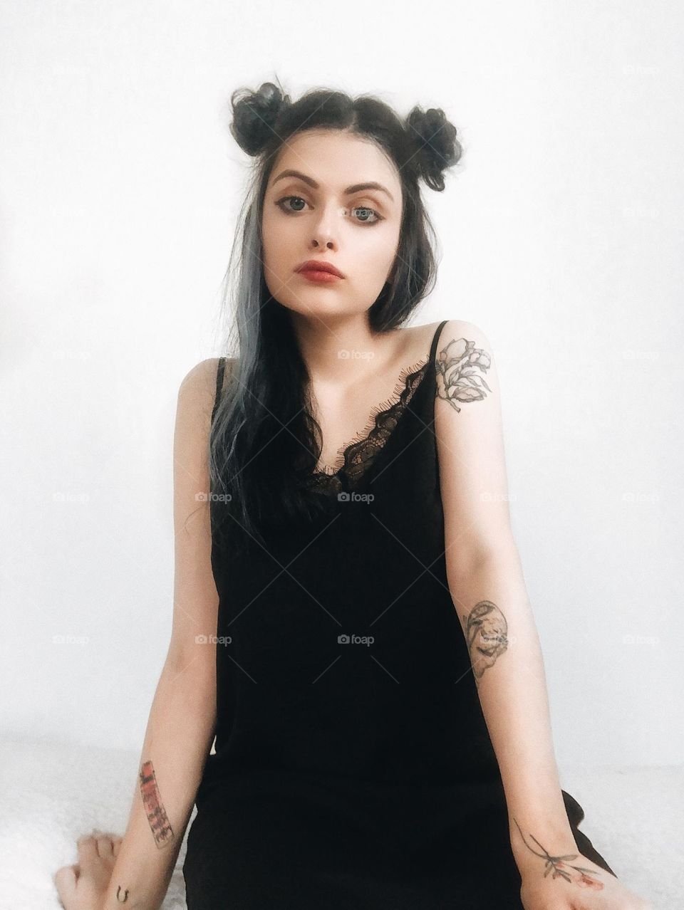 Portrait of a young woman in black with tattoos