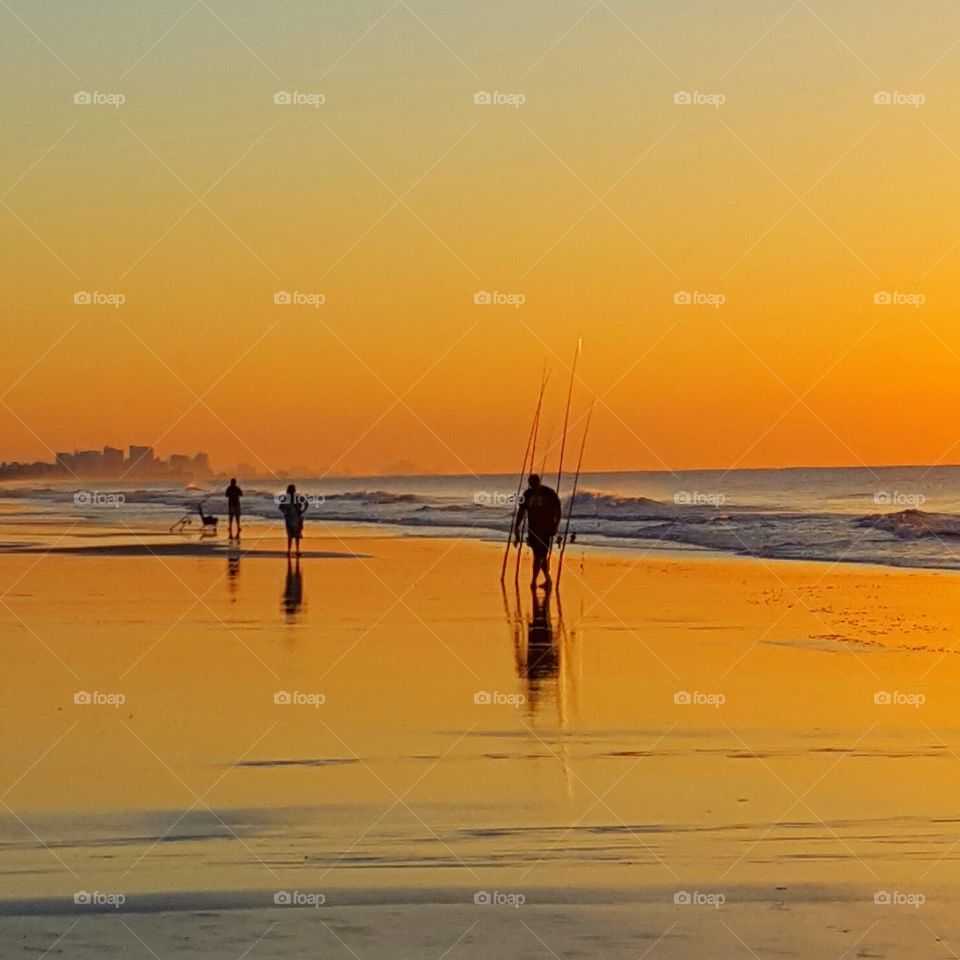 fishing on the beach at sunrise