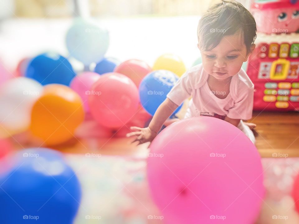 Pink balloon with baby dresses in pink, pink colored balloon at birthday party, baby celebrates in pink, pink birthday celebration, celebrating a one year old 