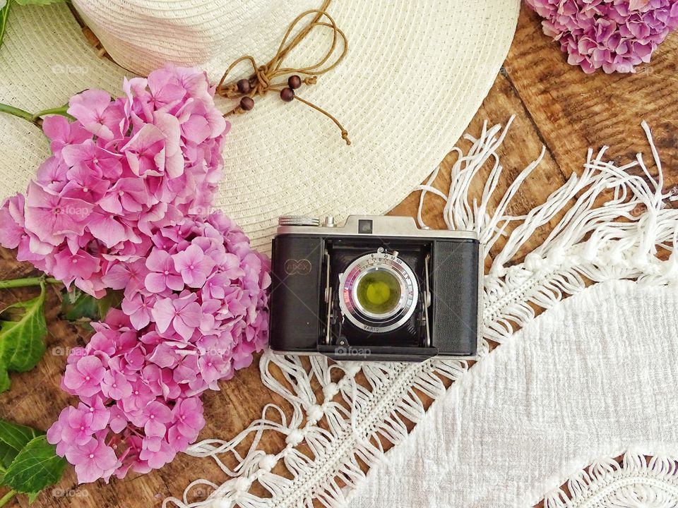 Still life with old camera and summer hat