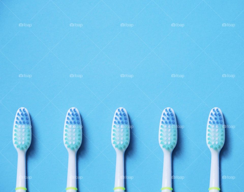 Overhead of toothbrushes on blue background 